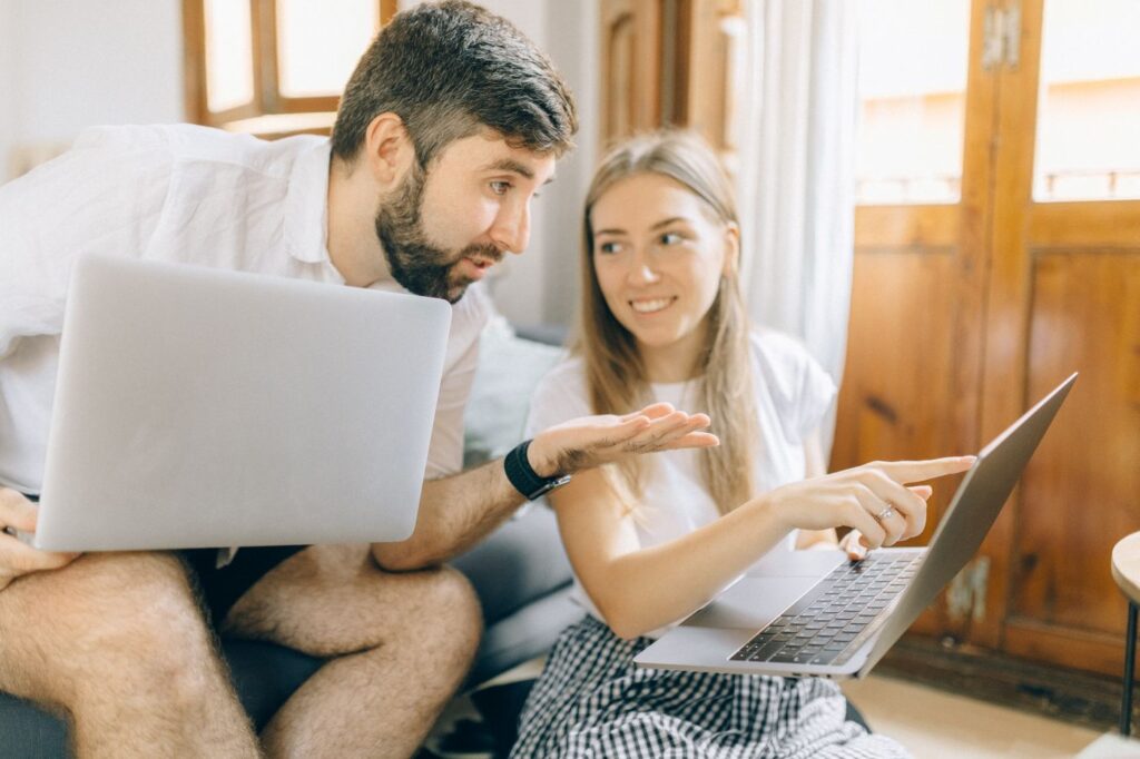 Couple comparant des sites sur laptop